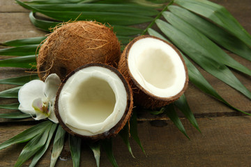 Coconuts with leaves and flower, on grey wooden background