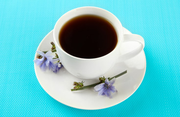 Cup of tea with chicory, on blue background