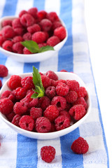 Ripe sweet raspberries in bowls, close up