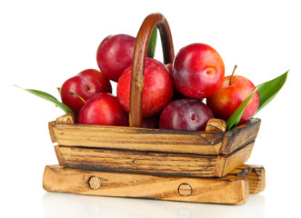 Ripe plums in basket isolated on white