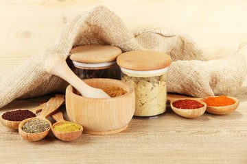 Fototapeta na wymiar Assortment of spices in wooden spoons and jars,