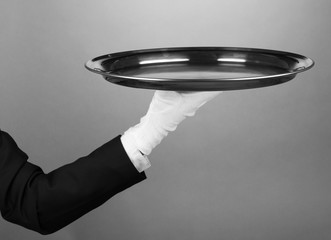 Empty tray in hand waiter on grey background
