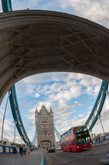 Red bus passing through the Tower Bridge in London.