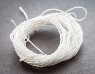 Coil of white rope on a dark background.