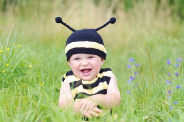 baby in bee costume on the meadow