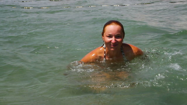 Young woman is swimming in the sea.