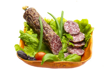 Ripe salami with salad, basil, onion and tomato