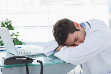 Obraz premium Tired doctor sleeping on his deck