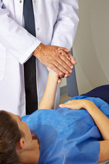 Fototapeta premium Arzt hält Hand einer Patientin