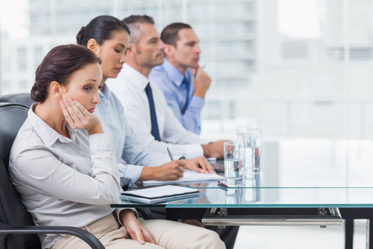 Businesswoman getting bored while attending presentation