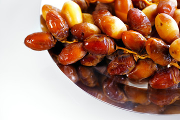 A tray of Arabic dates on a white background