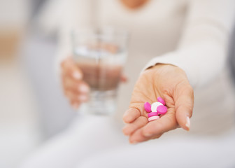 Closeup on pills in hand of young woman