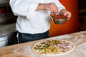 Cropped image of a chef preparing pizza