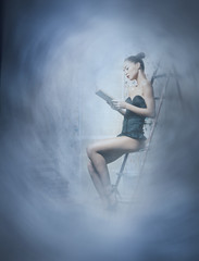 Fashion shoot of a young brunette woman reading a book