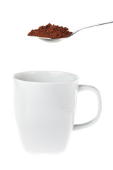 White coffee mug with a teaspoon of granulated instant coffee