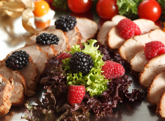 salad mix with berries and meat slaves on the silver plate