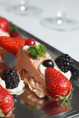 Salmon filet with fruit deko on silver plate