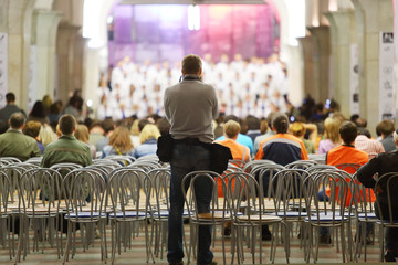 Back of photographer, which photographs choir