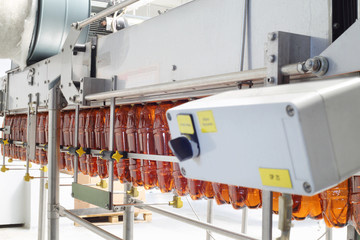 Brown plastic bottles for beer go on conveyor belt