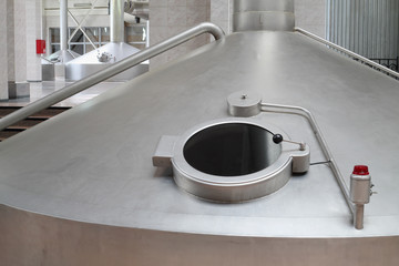 Big cistern with hatch for beer in factory