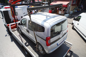 Truck loads fined car on street