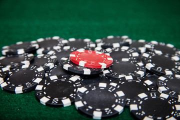 Pile of black poker chips with a single red one