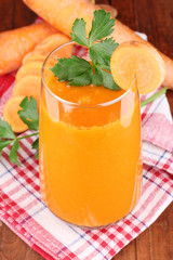 Glass of carrot juice on wooden table