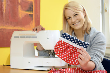 Frau mit Nähmaschine und Nähergebnis