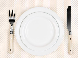 Knife, color plate and fork, on color background