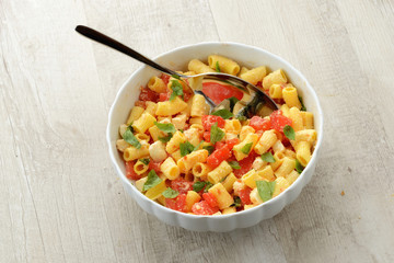 Piatto di pasta fredda con mozzarella, pomodori e basilico