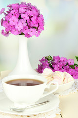 Beautiful bouquet of phlox with cup of tea