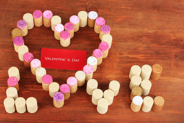 Wine corks laid out in form of heart on wooden table close-up
