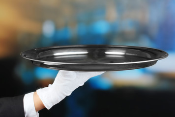 Empty tray in hand waiter on restaurant background