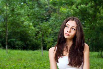 Naklejka na ściany i meble Thoughtful young woman outside in park