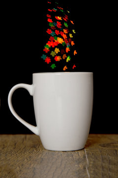 Bokeh heart spots of lights on background cup on wood