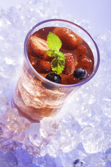 cold refreshment with .berries, mint and soda on ice cubes.