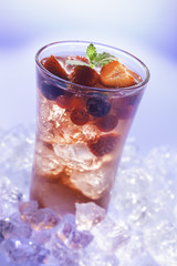 cold refreshment with .berries, mint and soda on ice cubes.
