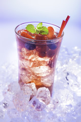 cold refreshment with .berries, mint and soda on ice cubes.