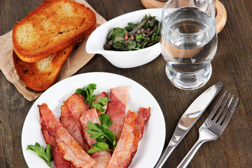 Bacon on plates on wooden table