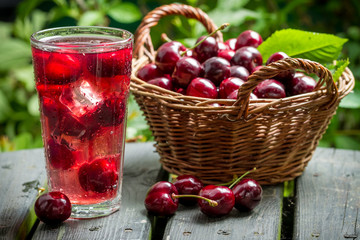Freshly harvested sweet cherries and juice from them with ice