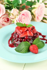 Tasty jelly dessert with fresh berries, on pink roses