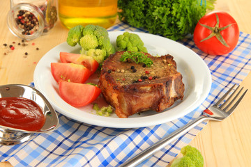 Piece of fried meat on plate on wooden table close-up