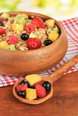 Oatmeal with fruits on table on bright background