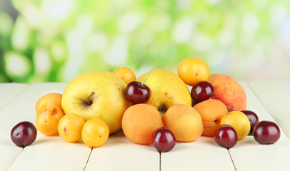 Naklejka na ściany i meble Bright summer fruits on wooden table on natural background