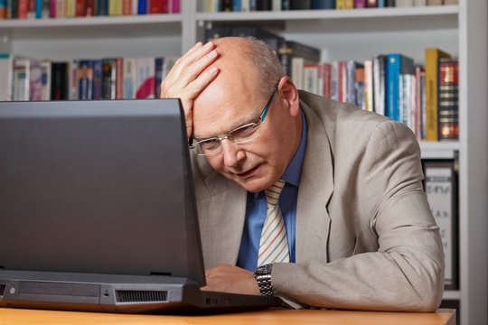 Enttäuschter und fassungsloser Senior vor Laptop