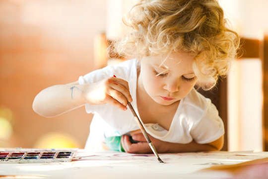 Portrait of little girl painting, summer outdoor