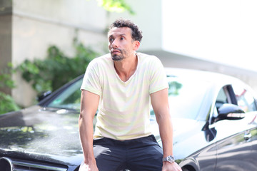 Mann sitzt auf einem Auto