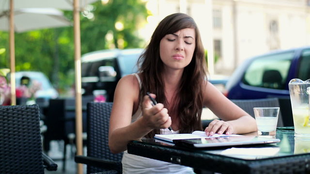 Angry, overwhelmed female student sitting in cafe