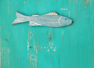 Blauer Holzfisch auf t&uuml;rkisem Holzuntergrund