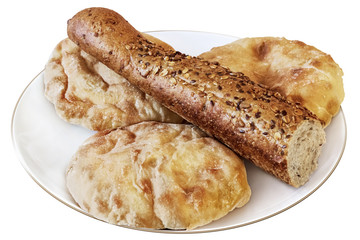 Three Pita Bread Loafs And Integral Baguette Half On White Plate